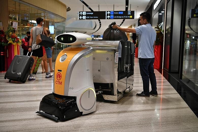 Left: Yi Wei, a robot deployed at Jewel Changi Airport, can pull a 1,000-litre bin along a pre-mapped route. Above: Ella, a scrub robot deployed at the National Gallery Singapore, is fitted with soft brushes for the conserved tiles. ST PHOTOS: CHONG 