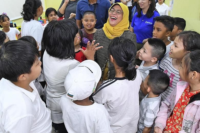 President Halimah Yacob interacting with children enrolled in the CareNights@Morning Star programme at Morning Star Community Services' Bedok North Centre yesterday. Under the programme, children get homework supervision and take part in various acti