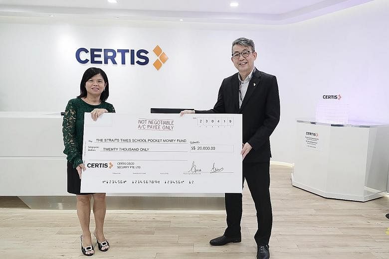 Mr Paul Chong presenting a mock cheque for $20,000 to Ms Tan Bee Heong, general manager of The Straits Times School Pocket Money Fund.