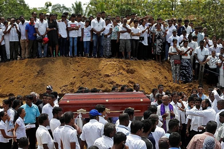 Above: Mourners carrying a casket during a mass for victims yesterday in Negombo. Sri Lankans observed three minutes of silence yesterday from 8.30am, the exact time when the first of six bombs were detonated on Easter Sunday. Right: Relatives mourni