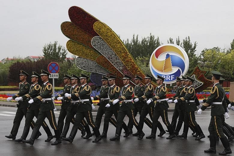 Chinese paramilitary personnel marching past a decor for the Belt and Road Forum outside the special plane terminal of the Beijing International airport. The summit, which starts today, boasts a hefty guest list of world leaders, including from all 1