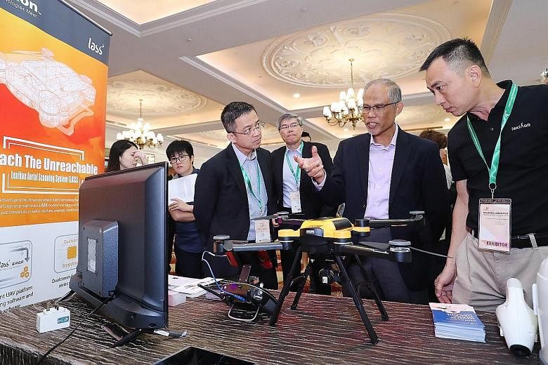 Minister for the Environment and Water Resources Masagos Zulkifli checking out a drone that helps to detect mosquito breeding grounds, at the event yesterday. With him are (from left) Mr Tan Meng Dui, chief executive of the National Environment Agenc