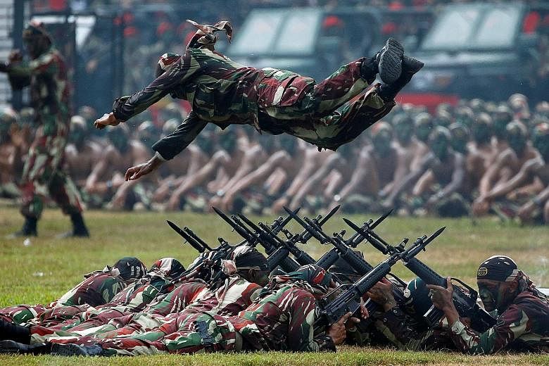 A Special Forces soldier performing a leap over a row of rifles topped with bayonets during celebrations for the 67th anniversary of the Indonesian Army's Special Forces in Jakarta yesterday. The troops conduct special operations missions such as unc