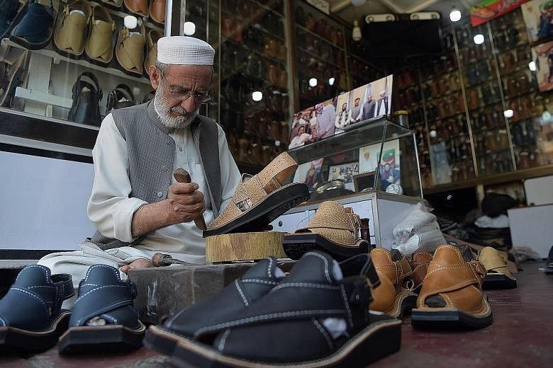 (Left) A Pakistani shoemaker in Peshawar making a pair of traditional chappal, which has inspired French shoe designer Christian Louboutin's new sandals (above).