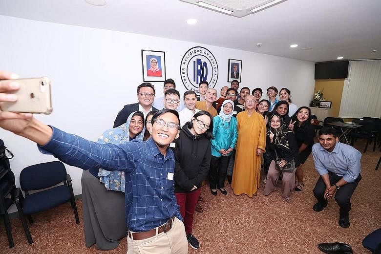 Inter-Religious Organisation youth leader Mohamad Saiful Md Anuar taking a wefie with President Halimah Yacob, who was flanked by IRO president Ben J. Benjamin and Venerable Kwang Phing, the IRO's vice-president, as well as other participants yesterd