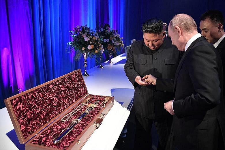 Mr Putin with Mr Kim after their talks yesterday. Beside them is a sword that was presented to the Russian leader. Mr Putin described the summit as "thorough one-on-one talks", while Mr Kim said he hoped to continue "fruitful and constructive" talks 