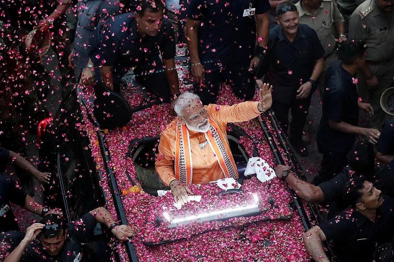 India's Prime Minister Narendra Modi waving at supporters during a roadshow in Varanasi on Thursday. He has so far chosen to represent Varanasi in Parliament and is not likely to pursue any other seat in the country's 39-day staggered general electio