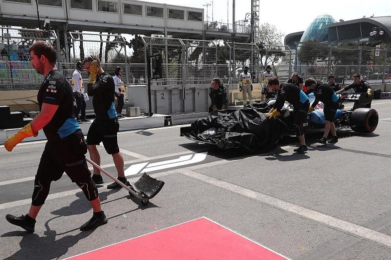 The Williams car of George Russell is recovered after the accident during the first practice session of the Azerbaijan Grand Prix yesterday.