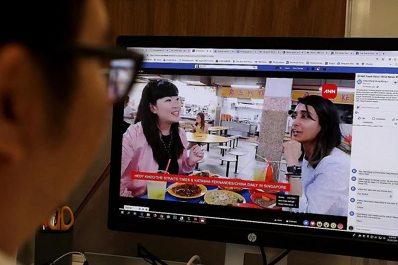 A viewer watching The Straits Times' STFood online editor Hedy Khoo (left) and Hong Kong's China Daily senior multimedia producer Natasha Fernandes' Facebook livestream yesterday from People's Park Centre in Singapore, where they tucked into local st