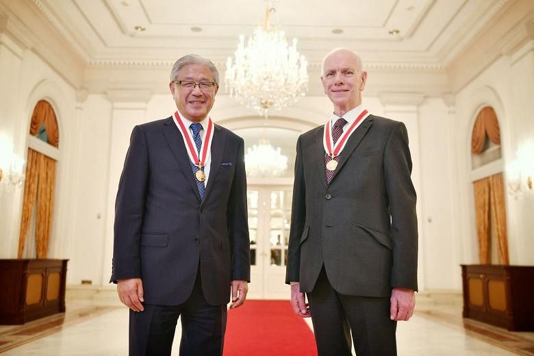 Professor Victor J. Dzau (left) and Professor John O'Reilly received their award from President Halimah Yacob at the Istana.
