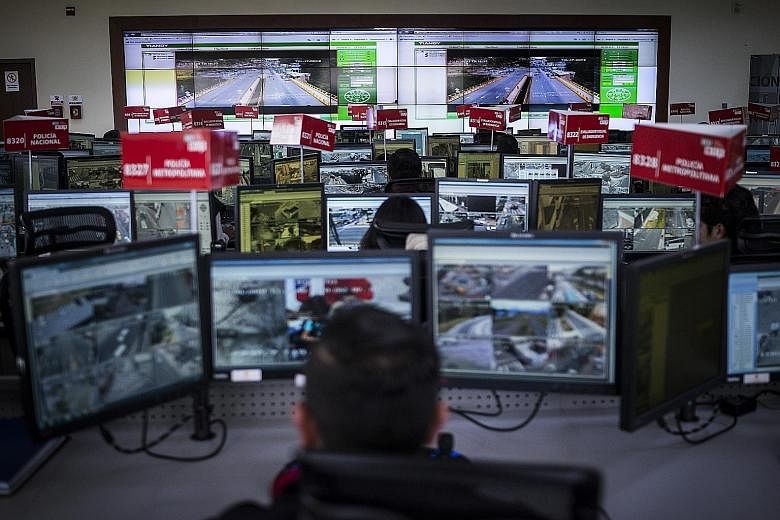 A control room of Ecuador's emergency response system. Police at 16 monitoring centres spend their days poring over footage from 4,300 high-powered cameras across the country. Armed with joysticks, they control the cameras and scan the streets for dr