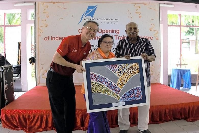 Ms Chen Wanyi, 31, a member of the Down Syndrome Association (Singapore), and the association's chairman R. Sivanandam presenting an art piece done by a DSA member to Minister of State for Social and Family Development Sam Tan at the opening of the I