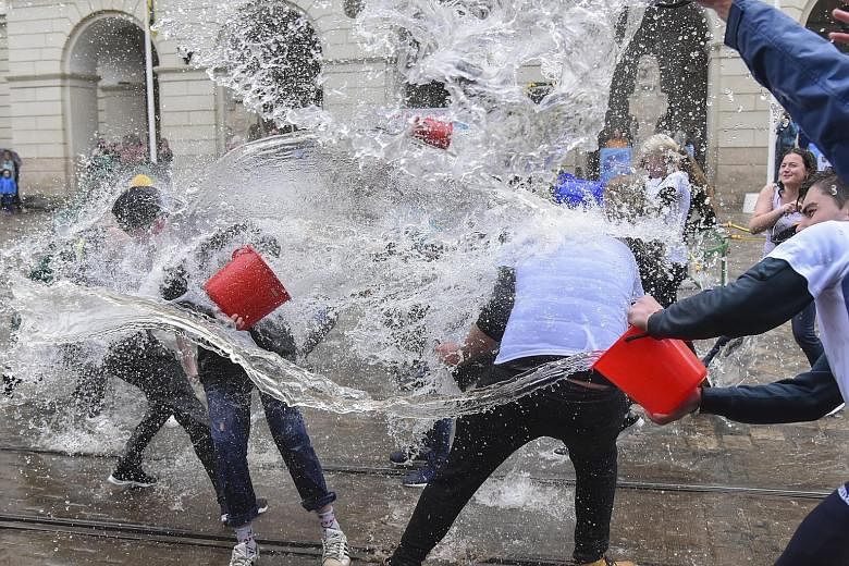 Ukrainians pouring water on each other in the western city of Lvivyesterday. The custom of pouring water is an ancient spring cleansing rite that takes place on Easter Monday.