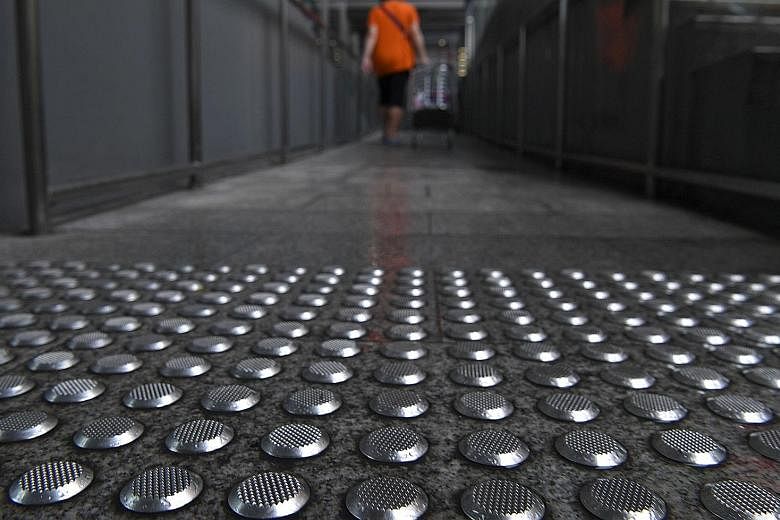 Nex shopping mall is replacing metal floor studs (left) around its premises after a man complained that a section of the studs becomes slippery in wet weather. They are meant to warn the visually impaired of upcoming stairs or escalators, and are sit