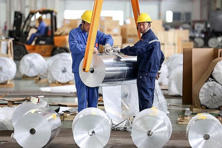 Workers packing aluminium sheets at a factory in Huaibei, in China's Anhui province. The country's manufacturing Purchasing Managers' Index stood at 50.1 last month, down from 50.5 in March.