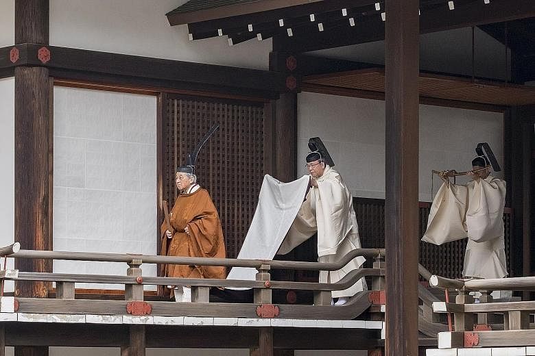 Prime Minister Shinzo Abe (above) and his wife Akie Abe bowing as they arrived for Emperor Akihito's abdication ceremony at the Imperial Palace in Tokyo yesterday. PHOTO: BLOOMBERG Left: Emperor Akihito (far left) attending the Taiirei Tojitsu Kashik