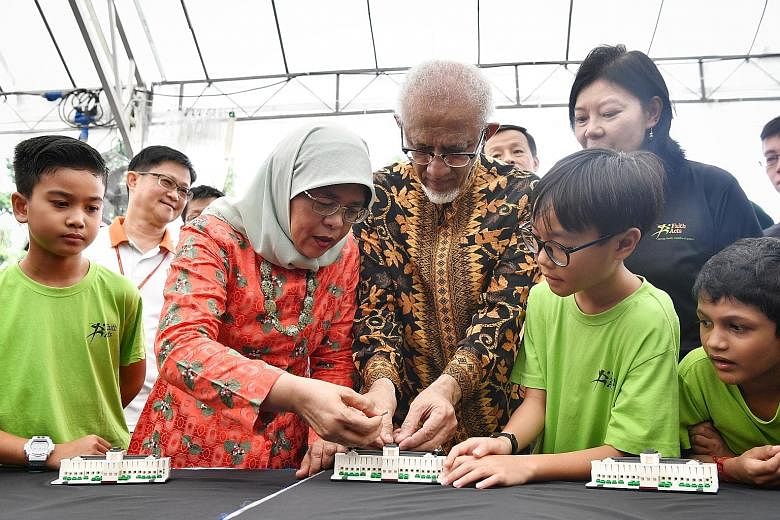 The model, created with 200 Lego bricks, was commissioned by the President's Office and unveiled to commemorate the Istana's 150th anniversary this year. Seven-year-old Ong Ryu Joon (in red shirt), with his father Michael Ong (in green), launching a 