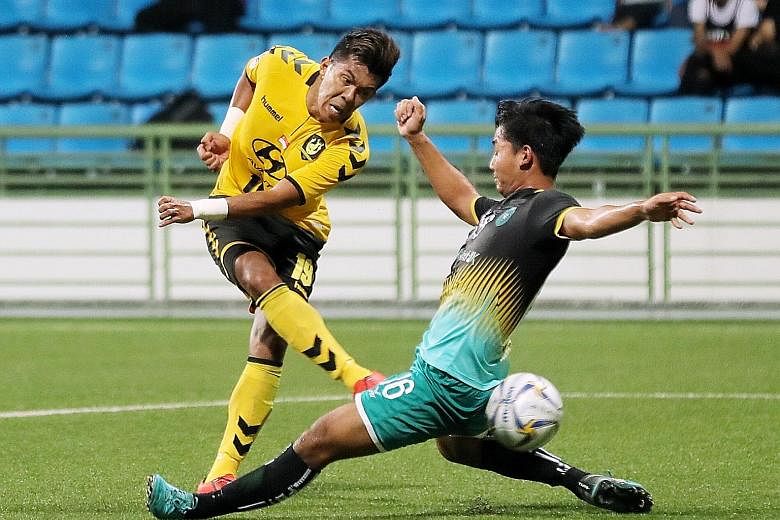 Tampines Rovers' hat-trick hero Khairul Amri taking a shot past lunging Yangon United defender Thu Rein Soe in their AFC Cup Group F match at the Jalan Besar Stadium yesterday. Tampines won 4-3.