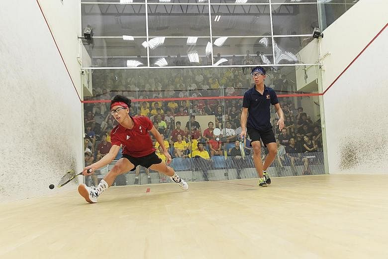 Hwa Chong Institution's Jovan Lee (in red) playing against Rudy Johari of Anglo-Chinese School (Independent) in the third match of the Schools National boys' A Division squash team final at Kallang Squash Centre yesterday.