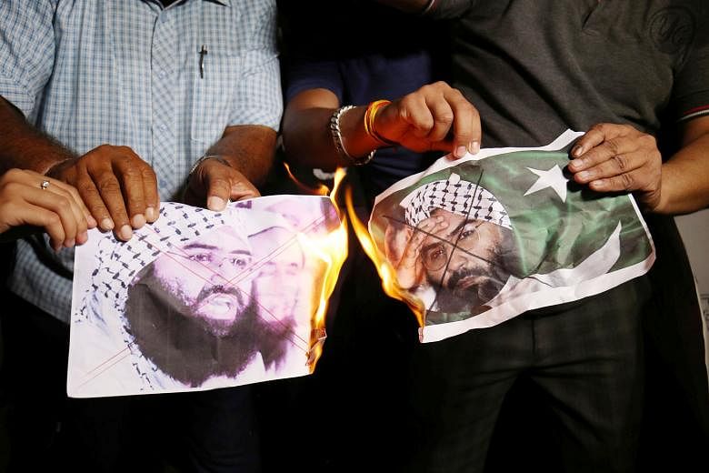 Indians burning pictures of Masood Azhar, head of the Pakistan-based militant group Jaish-e-Mohammed, as they celebrated the UN Security Council committee's decision on Wednesday to blacklist the terrorist. 