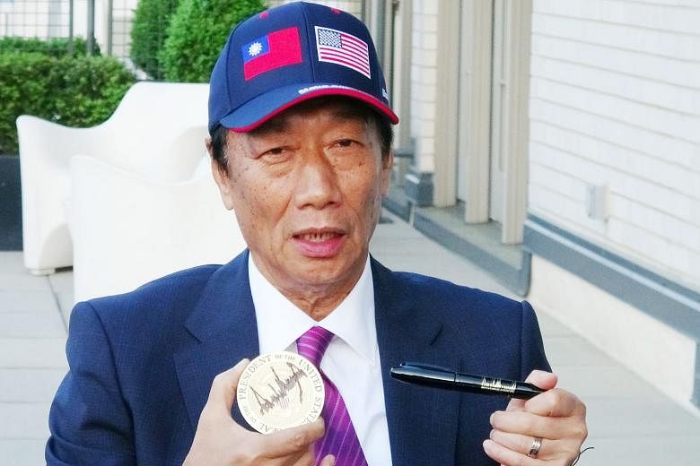 Prospective Taiwanese presidential candidate Terry Gou showing a coaster and pen embossed with US President Donald Trump's signature after their meeting at the White House on Wednesday.