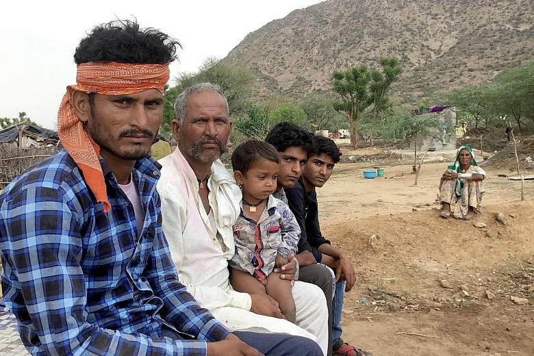 Mr Baghrawat Panwar (far left), 30, a member of the Banjara community now settled near the foothills of the ancient Aravalli range. The settlement is shorn of any public utilities. None of the residents has been given ownership of the land they are s