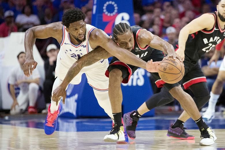 Philadelphia 76ers centre Joel Embiid (far left) guarding Toronto Raptors forward Kawhi Leonard during their National Basketball Association play-off semi-final on Thursday. The duo had 33 points each but hosts Sixers won 116-95 for a 2-1 series lead