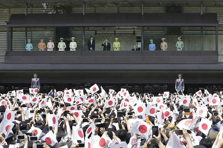 Japan's Emperor Naruhito waving as Empress Masako (centre right) stands with other members of the Japanese imperial family during a greeting ceremony at the Imperial Palace in Tokyo yesterday. The ceremony was attended by 141,130 people. PHOTO: BLOOM
