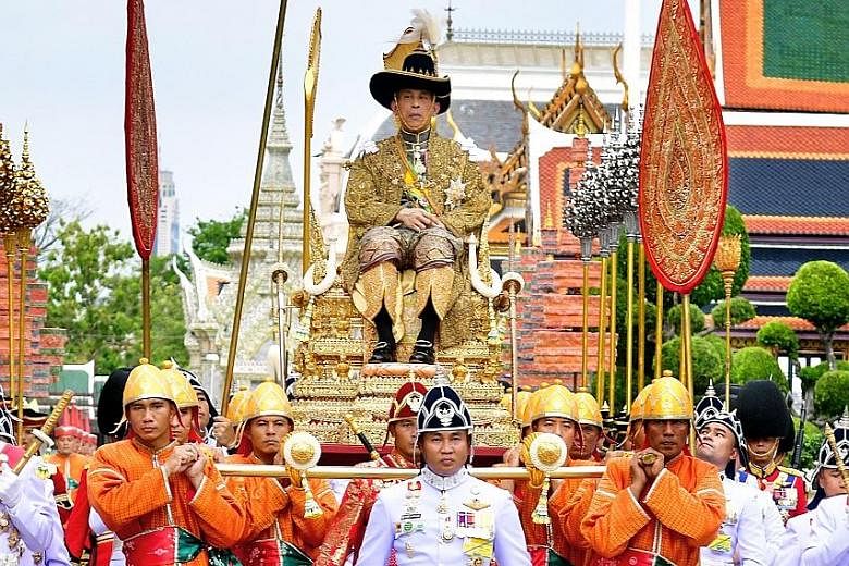 Thailand's King Maha Vajiralongkorn sitting on a golden royal palanquin following his coronation ceremony at the Grand Palace in Bangkok yesterday. Also known as King Rama X, he was formally crowned yesterday as part of an elaborate three-day ceremon