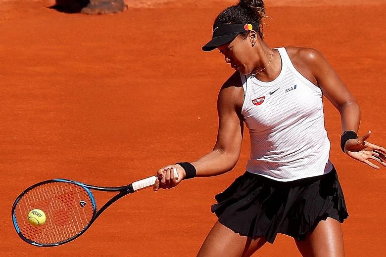 Naomi Osaka hitting a return against Dominika Cibulkova in the first round of the Madrid Open yesterday. The Japanese won in straight sets and will next face Spain's Sara Sorribes Tormo. PHOTO: EPA-EFE