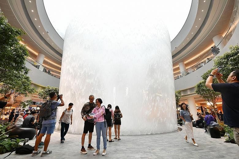 Visitors checking out the indoor waterfall at Jewel Changi Airport, a 10-storey retail complex with passenger check-in services that opened last month.
