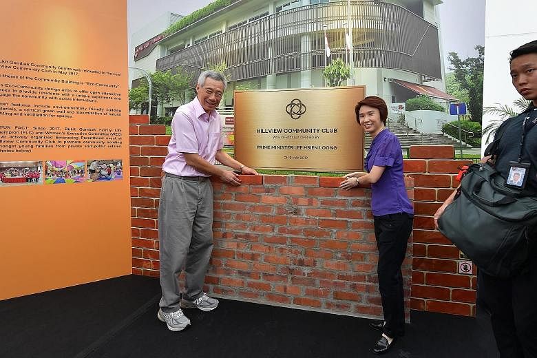 Prime Minister Lee Hsien Loong placing a symbolic brick at the new Hillview Community Club yesterday, in memory of the brick laid by former prime minister Lee Kuan Yew at the same site 56 years ago. PM Lee was with his father on that occasion. Beside