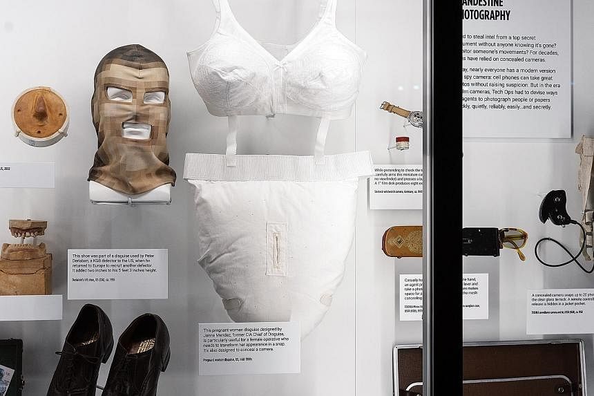 Clockwise from above left: An exhibit on the assassination of Russian revolutionary Leon Trotsky; an East German microdot message in a hollow tooth; and a fake pregnancy suit from the mid-1980s and other disguises.