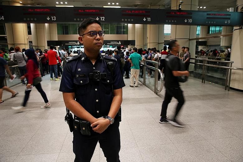 Sergeant Salehudin Samsudin (left) has to be alert at all times. Recently, he spotted a suspicious-looking man who turned out to be travelling under multiple identities.
