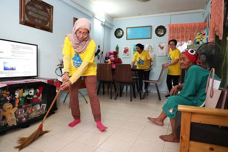Volunteer Juzailah Abd Rahim 39, an assistant manager, cleaning the home of Madam Tumi Teron, 89, yesterday. As part of the Courts Charity Home programme, 14 Courts employee volunteers helped to deliver some products and cleaned the beneficiaries' ho