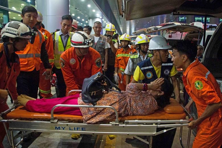 Rescue workers transporting an injured woman who was on board the Biman Bangladesh Airlines flight yesterday. The plane slid off the runway when a storm hit the city.