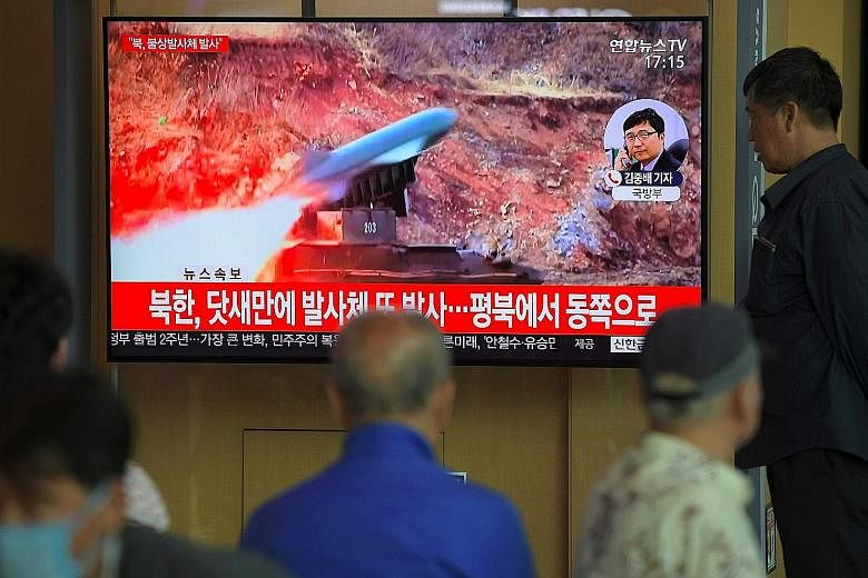 Passers-by in Seoul watching old footage of North Korea's projectile weapons yesterday. South Korea voiced "grave concern" about yesterday's missile launch, saying it would not help efforts to improve inter-Korea ties and ease military tensions on th