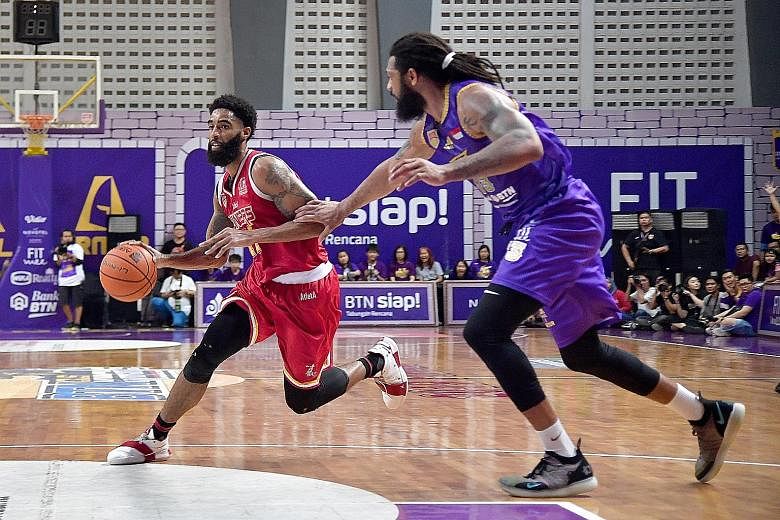 Singapore Slingers' Jerran Young being guarded by CLS Knights Indonesia's Darryl Watkins in Game 3 of the Asean Basketball League Finals in Surabaya on Wednesday. He has overcome a hamstring injury in their Game 1 loss to help the team come back with