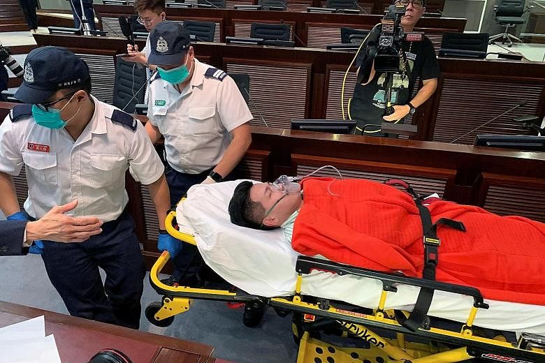 Pro-democracy lawmaker Gary Fan being carried away on a stretcher yesterday after he collapsed during clashes between the two rival camps. Pro-democracy lawmakers clashing with their pro-Beijing counterparts yesterday, with both sides fighting for co