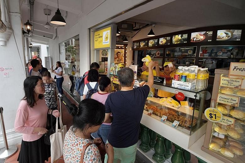 A steady stream of SPH direct subscribers redeeming their curry puffs at the Old Chang Kee Coffee House @ Rex yesterday. 