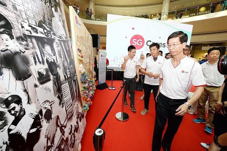 Dr Ang Hak Seng, Deputy Secretary of the Ministry of Culture, Community and Youth (foreground), and Speaker of Parliament Tan Chuan-Jin (middle) viewing a mural project at Suntec City yesterday.