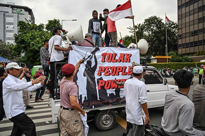 Members of the Islam Defenders Front and supporters of presidential candidate Prabowo Subianto confronting a group on the back of a pick-up truck supporting the General Elections Commission - tasked with counting the ballots of the recent Indonesian 