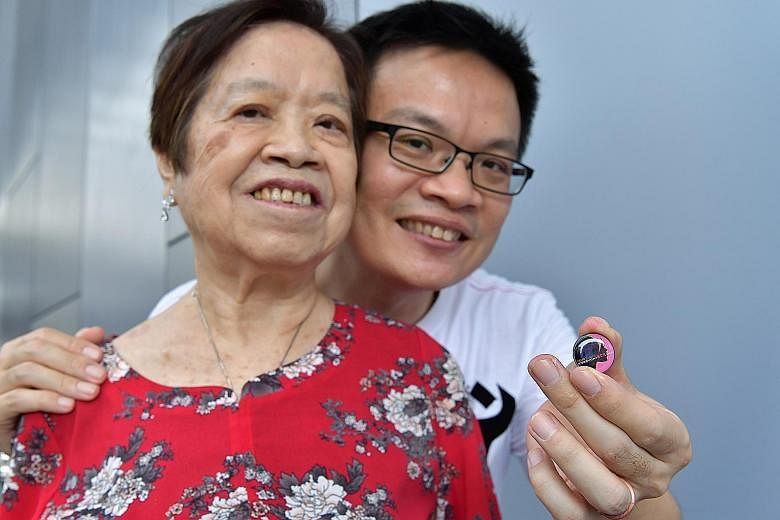 Police NSman and HomeTeamNS volunteer Jenson Goh, 45, with his 73-year-old mother Cheng Song Eng. The collar pin was given to her at the event at Our Tampines Hub yesterday.