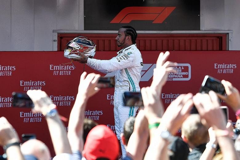 Mercedes' British driver Lewis Hamilton celebrating his Spanish Grand Prix victory yesterday. His fastest lap in the race also earned him an extra point.