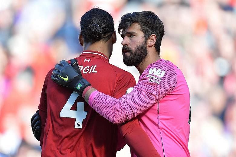 Defender Virgil van Dijk (left), PFA Player of the Year, getting a pat from Golden Glove winner Alisson after Liverpool beat Wolves 2-0 at Anfield yesterday. There were personal accolades aplenty for the Reds but no trophy. PHOTO: EPA-EFE