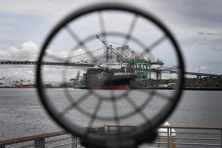 A container ship - viewed through the sights of a museum gun - unloads its cargo in California. If tariffs escalate, the US economy would shrink by 0.6 per cent, according to the International Monetary Fund, while China's economy could contract by 1.