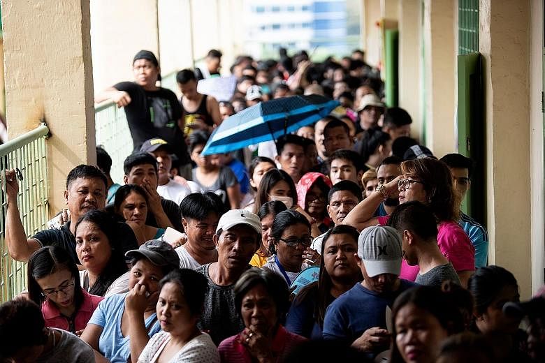Filipinos waiting to vote at Culiat Elementary School in Manila yesterday. The midterm polls are expected to strengthen President Rodrigo Duterte's grip on power, opening the way for him to deliver on pledges to restore the death penalty and rewrite 