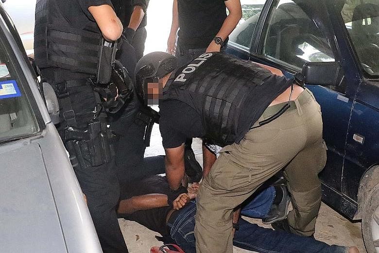 Officers from the Malaysian police's counter-terrorism division detaining a 34-year-old labourer, believed to be the cell's mastermind, in Terengganu on May 5.