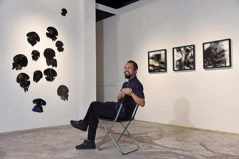 Repeat, Repeat, Repeat: Revising The Phenomenon Of Printing curator Zaki Razak is seen here with Miguel Chew's Beauty Lie On The Eye Of The Beholder 1.1 (far left) and Yeo Shih Yun's Impossibility Of Repetition (left).