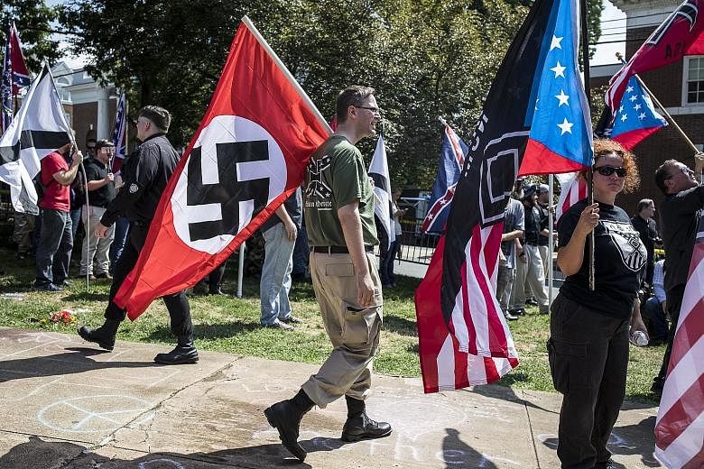 White supremacists opposed to the removal of a Confederate monument taking part in a demonstration in Charlottesville, Virginia, on Aug 12, 2017. One of the slogans chanted by the white nationalists - "You will not replace us" - was a variation on a 